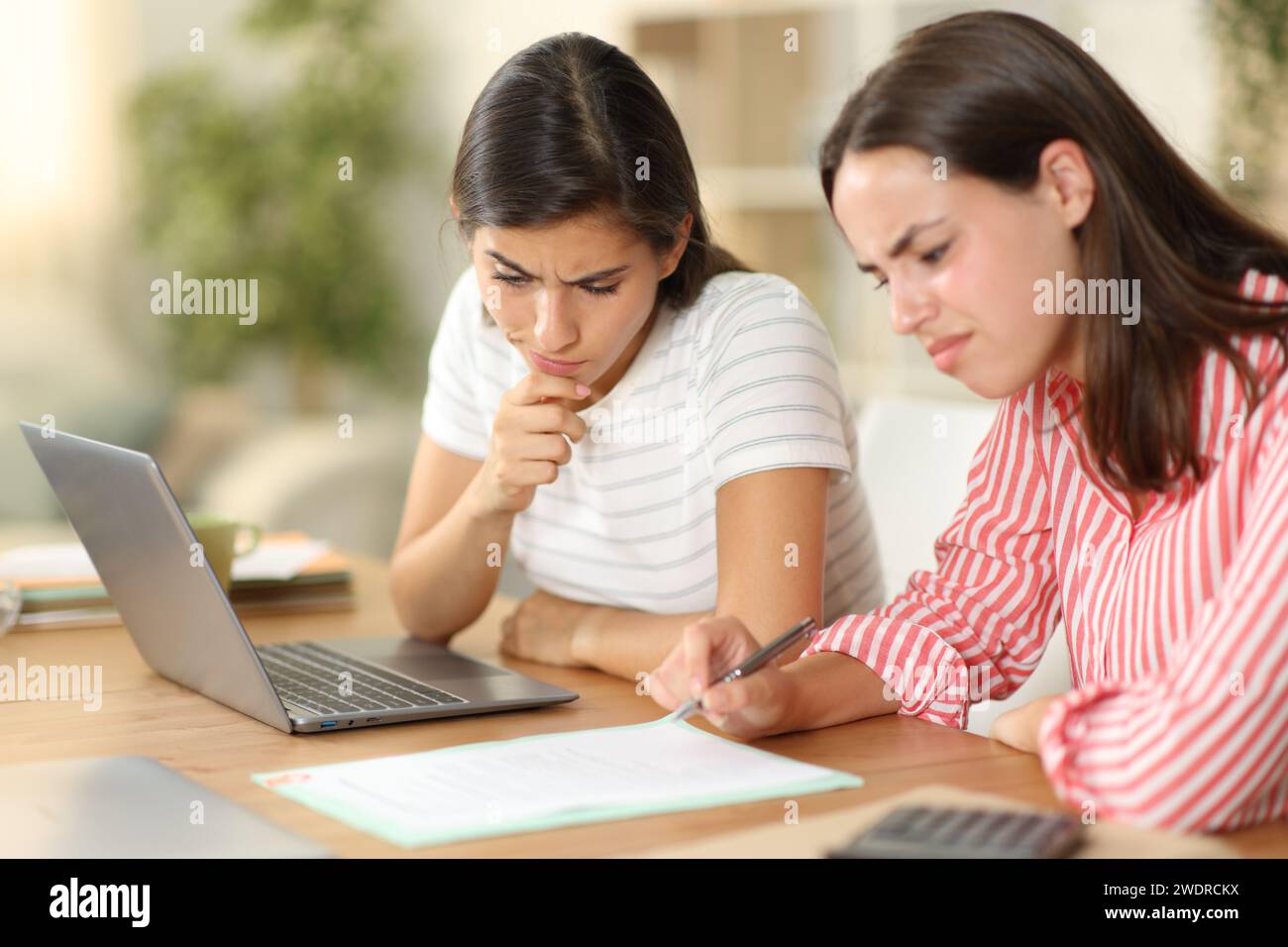 Telelavoratori sospetti che controllano il contratto che lavorano a casa Foto Stock