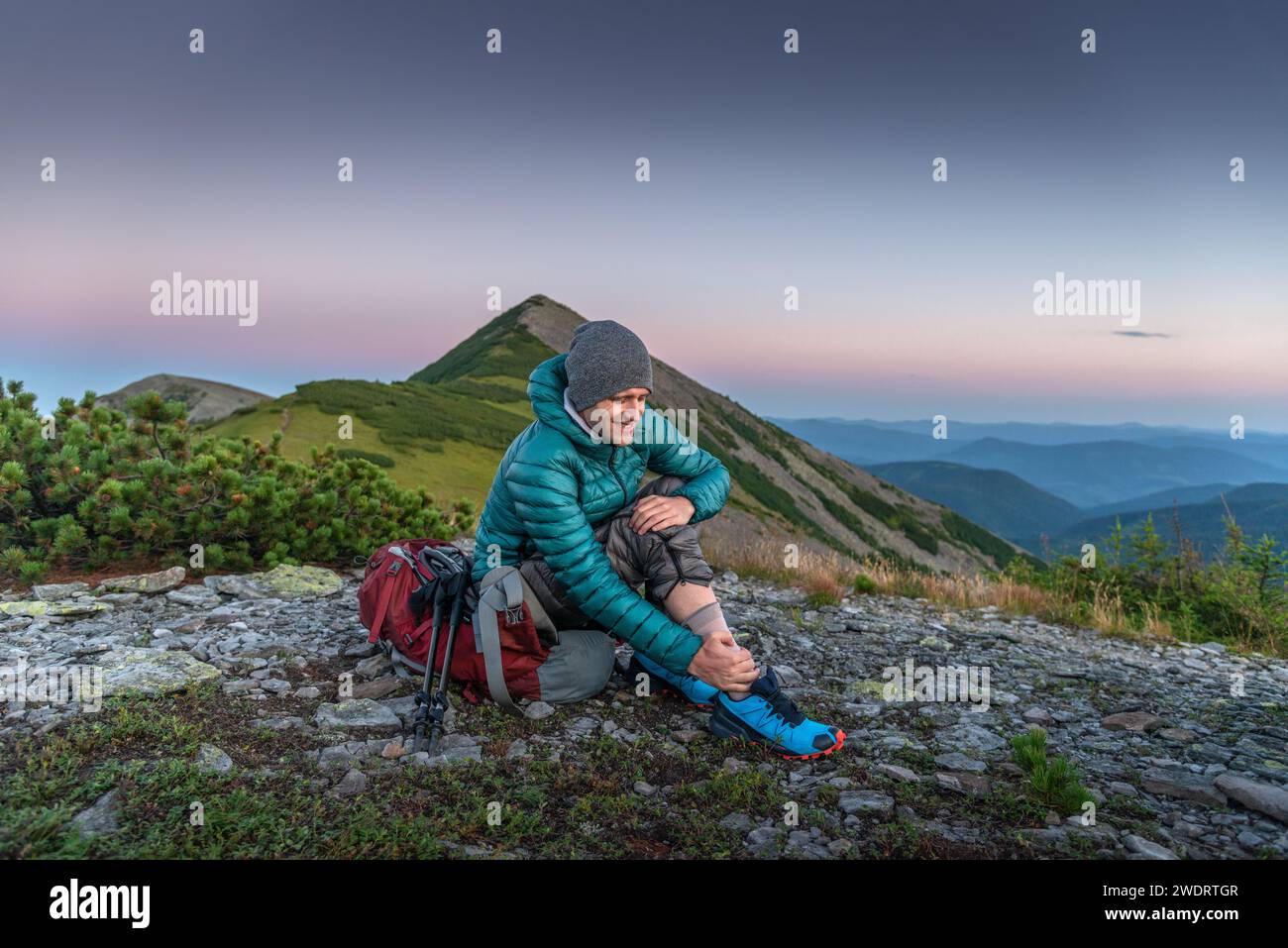 Hiker Man ha problemi con la caviglia in montagna Foto Stock