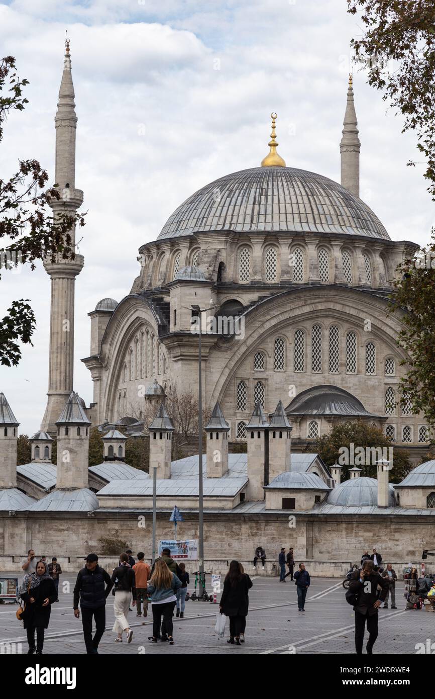 Persone che camminano su una piazza di Istanbul con una moschea sullo sfondo Foto Stock