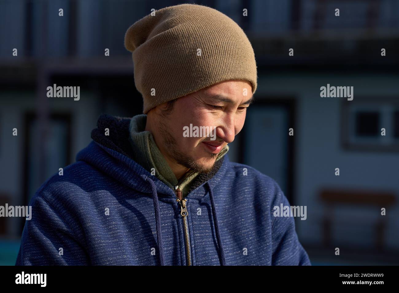 Un uomo in abiti caldi trabocca dal sole luminoso Foto Stock