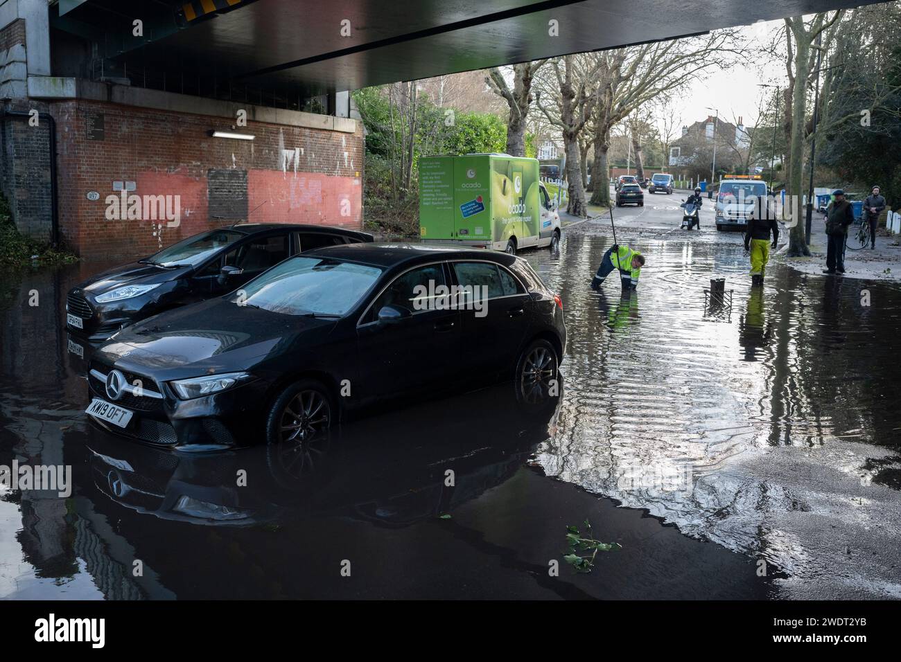 Le automobili rimangono abbandonate sotto il ponte ferroviario sull'East Dulwich Grove nel Dulwich Village, dopo una perdita d'acqua in un vicino incrocio stradale, il 22 gennaio 2024, a Londra, in Inghilterra. Foto Stock