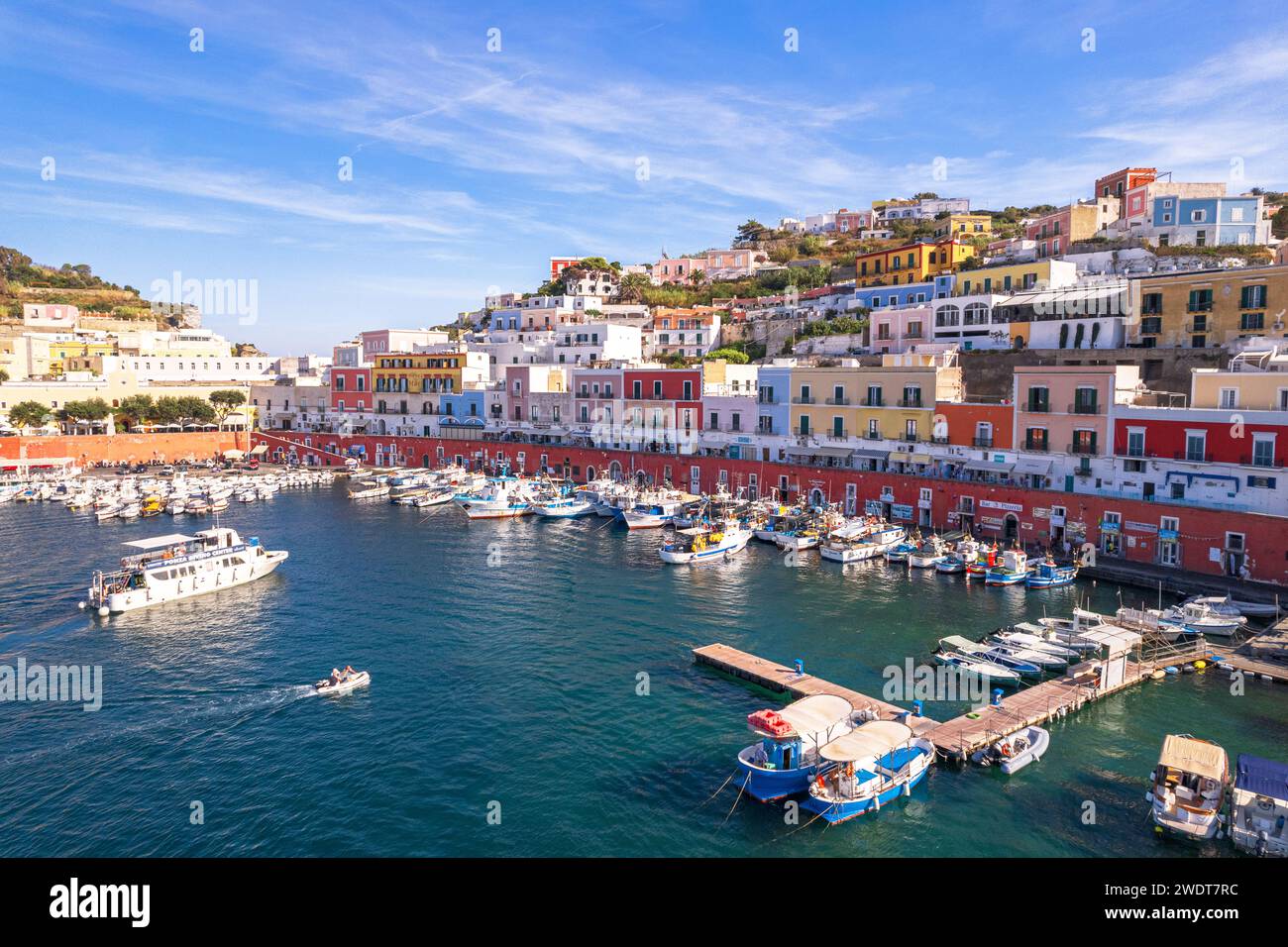 Il porto di pescatori dell'isola di Ponza con le tipiche case colorate sul lungomare, l'isola di Ponza e l'arcipelago pontino Foto Stock