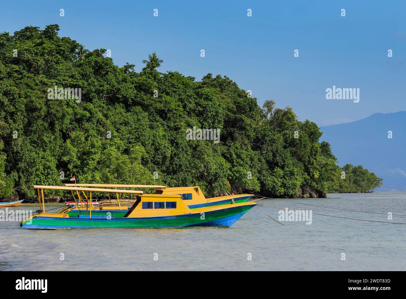 I traghetti ormeggiavano nella baia centrale di questa vacanza orlata da coralli e destinazione per immersioni subacquee, Bunaken Island, Sulawesi settentrionale, Indonesia Foto Stock