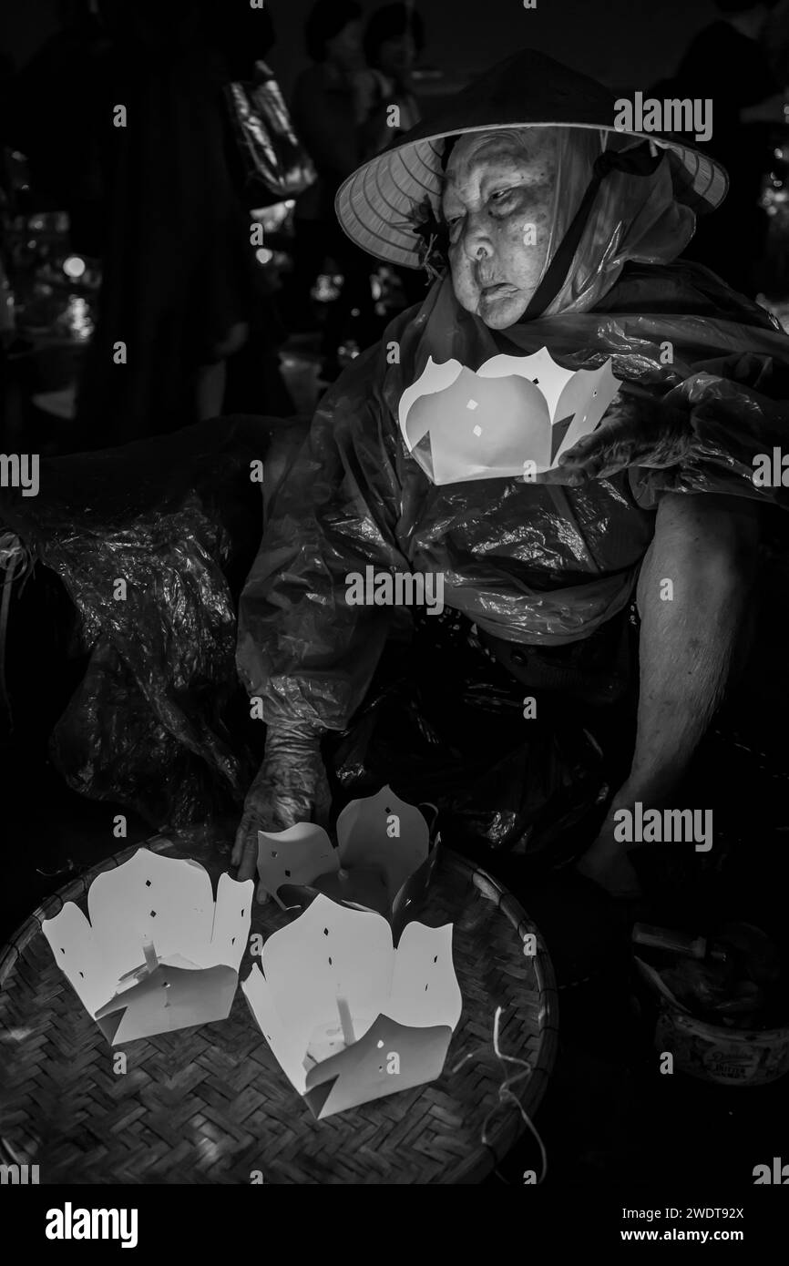 La povera donna vende lanterne e candele a Hoi An in Vietnam Foto Stock