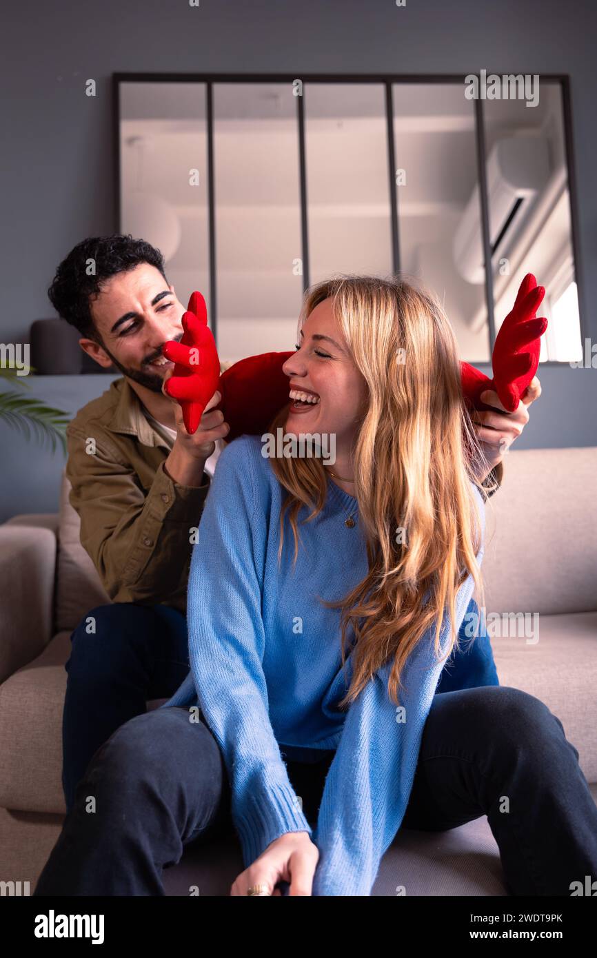 Giovani coppie che festeggiano San Valentino, sorridono e abbracciano un cuore... verticale Foto Stock