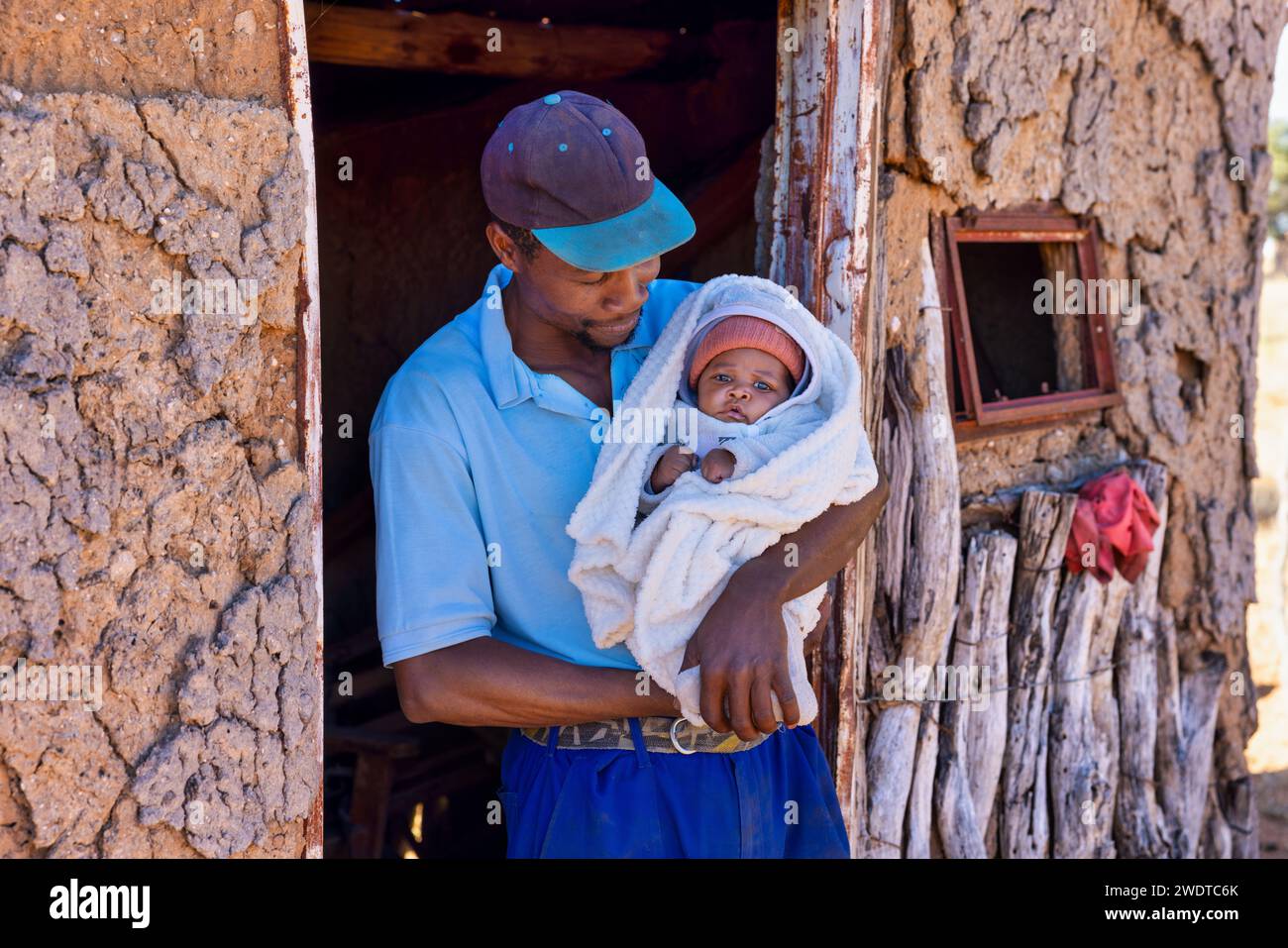 Genitore single che tiene il suo neonato, paternità, villaggio in Botswana Foto Stock