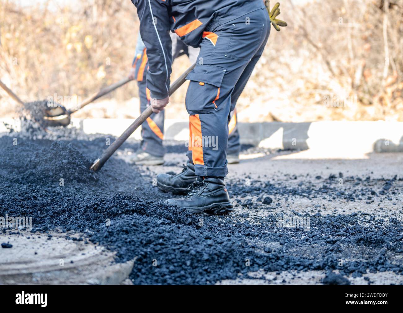 Materiale fotografico di magazzino per cantieri stradali, posa di una nuova superficie di asfalto, macchine per impieghi gravosi, lavoratori edili, lavori di pavimentazione Foto Stock