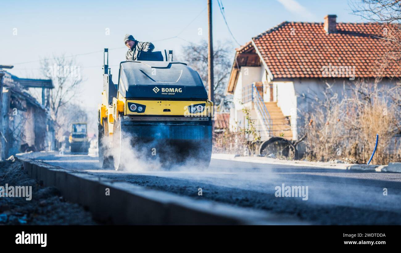 Materiale fotografico di magazzino per cantieri stradali, posa di una nuova superficie di asfalto, macchine per impieghi gravosi, lavoratori edili, lavori di pavimentazione Foto Stock