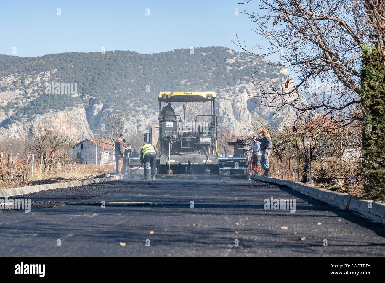 Materiale fotografico di magazzino per cantieri stradali, posa di una nuova superficie di asfalto, macchine per impieghi gravosi, lavoratori edili, lavori di pavimentazione Foto Stock