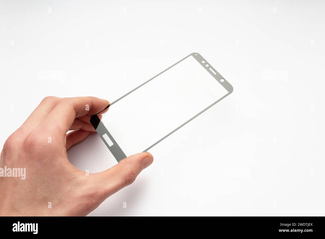 Vetro protettivo per smartphone in mano a un uomo su sfondo bianco. Protezione dello schermo per smartphone. Foto Stock