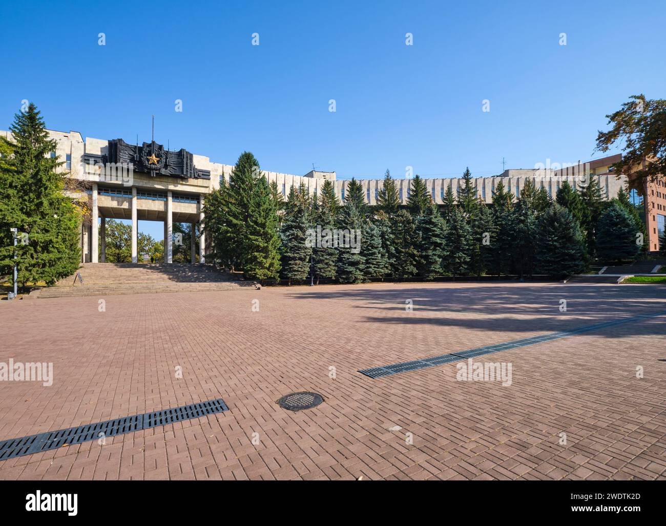 Un esempio di architettura commerciale sovietica, socialista russa, modernista. Con un grande sigillo in bronzo, una scultura con stemma e una stella d'oro. All'esercito Foto Stock