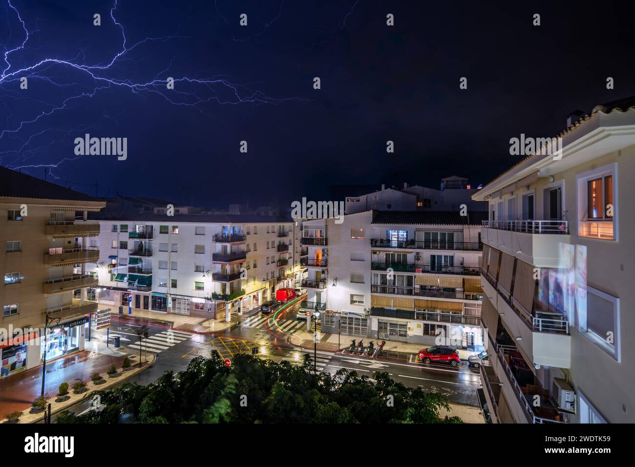 Una vivace strada cittadina illuminata di edifici di notte Foto Stock