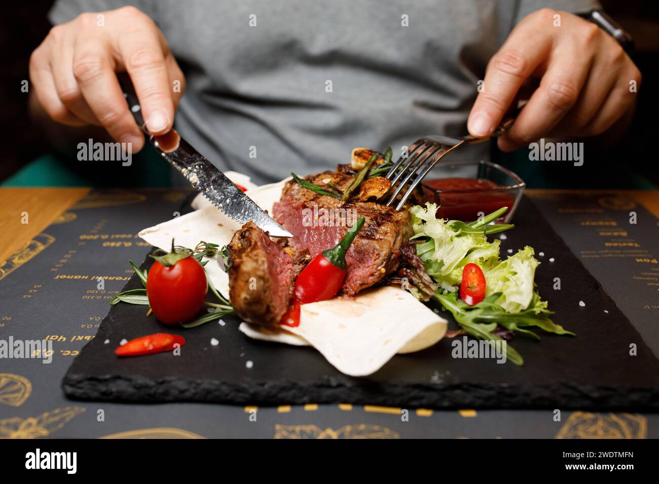 bistecche a bordo, carne a mano al ristorante. Foto di alta qualità Foto Stock