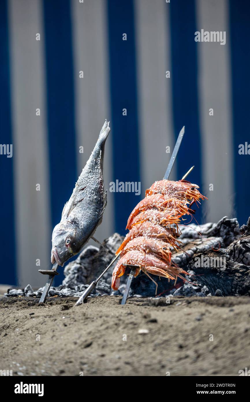 Cucina a base di pesce sul barbecue in spiaggia. Foto Stock