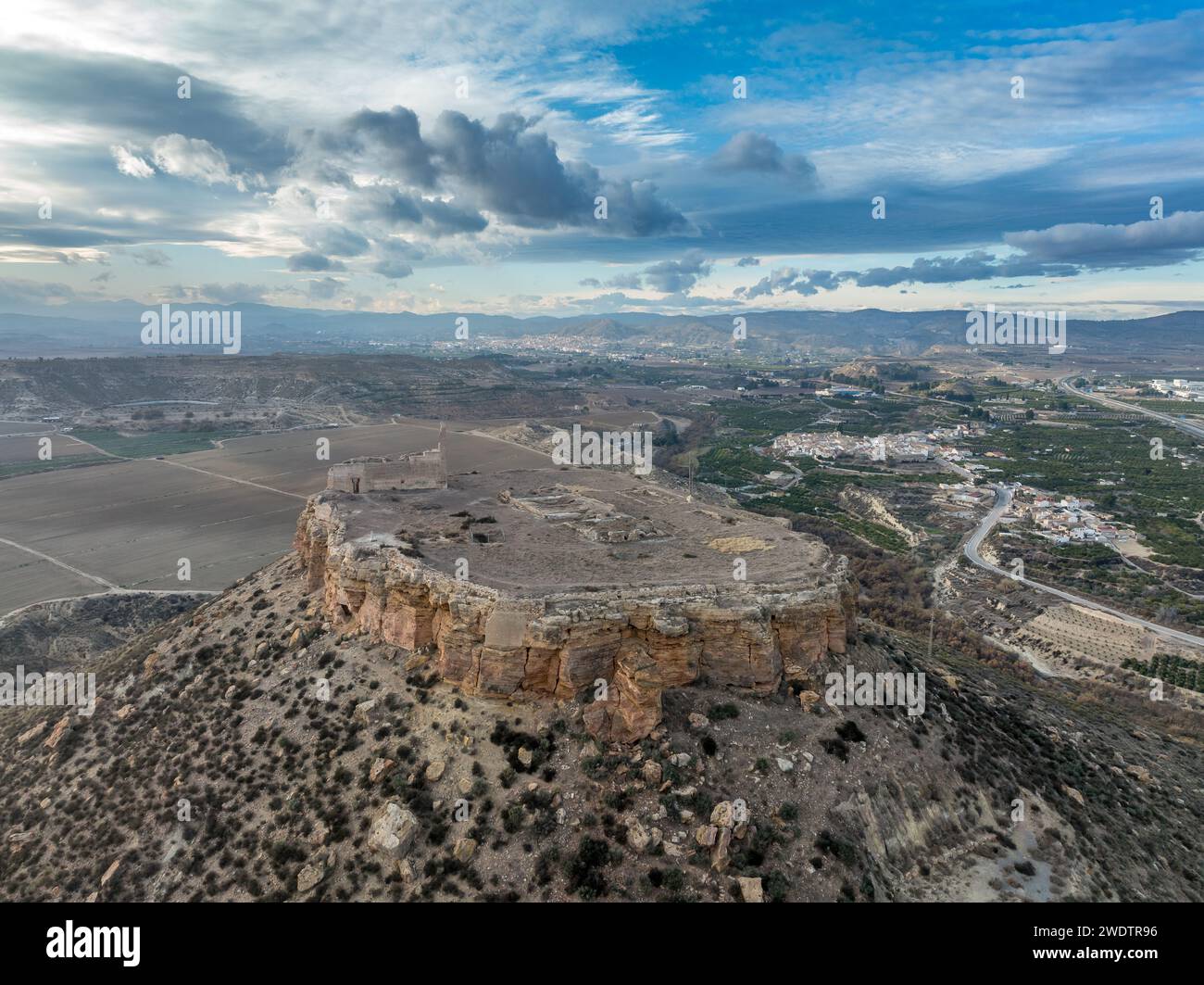 Vista aerea di Castillo de Alcalá o Castillo de la Puebla, castello arabo nella provincia di Murcia, in Spagna, sulla cima di una montagna calcarea con cima piatta. Foto Stock