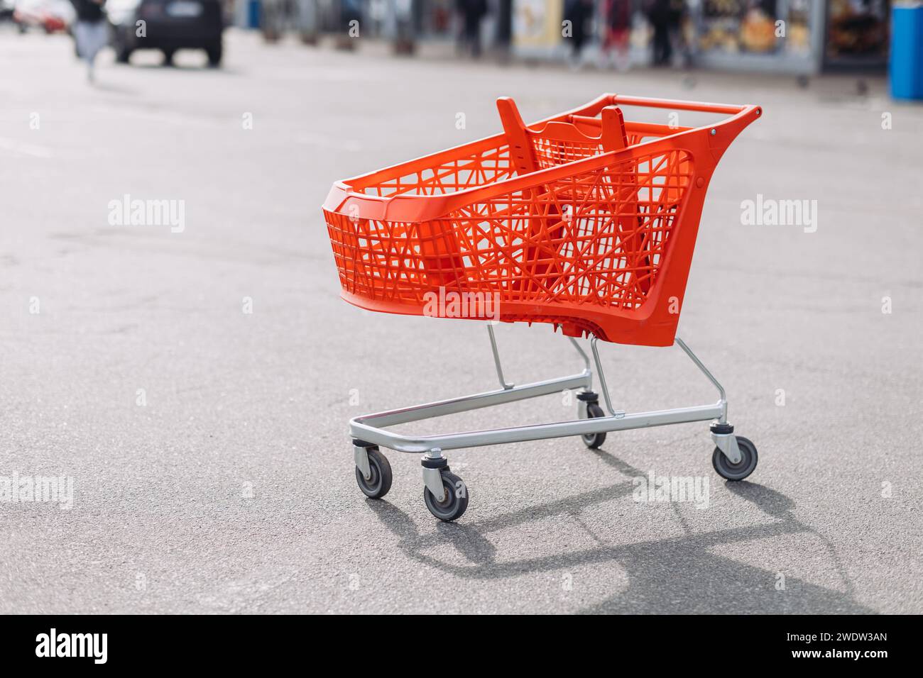 Un cestino rosso del supermercato nel parcheggio. Foto di alta qualità Foto Stock