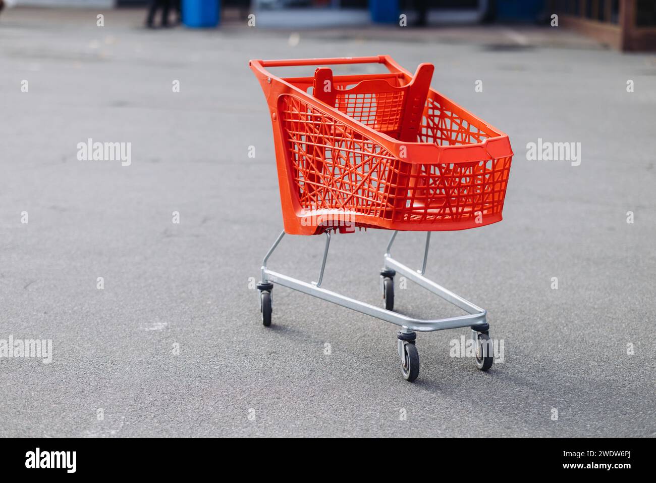 Un cestino rosso del supermercato nel parcheggio. Foto di alta qualità Foto Stock