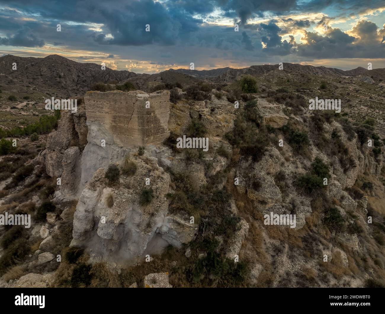 Vista aerea delle rovine medievali del castello di Rio di origine araba nei pressi di Aspe, Spagna, con il suggestivo cielo al tramonto Foto Stock