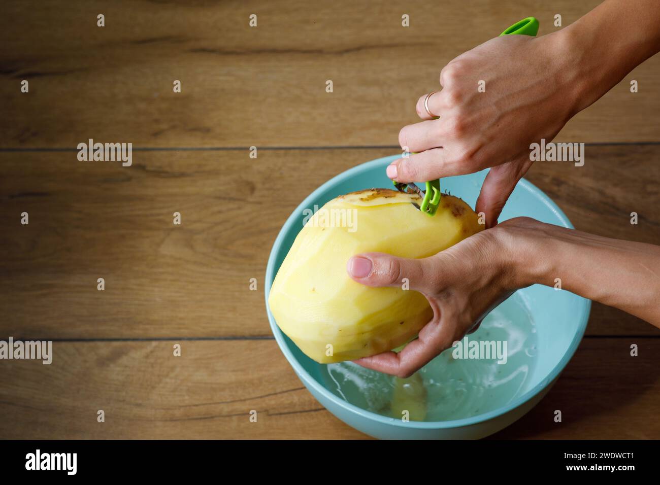 pulire le patate a casa con le mani, una ciotola e l'acqua Foto Stock