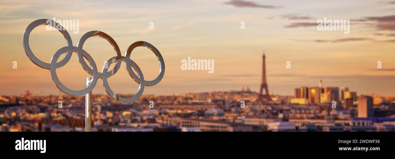 Anelli olimpici al tramonto con la Torre Eiffel a Parigi, sfondo panoramico, banner web dei giochi olimpici estivi di Parigi 2024 Foto Stock