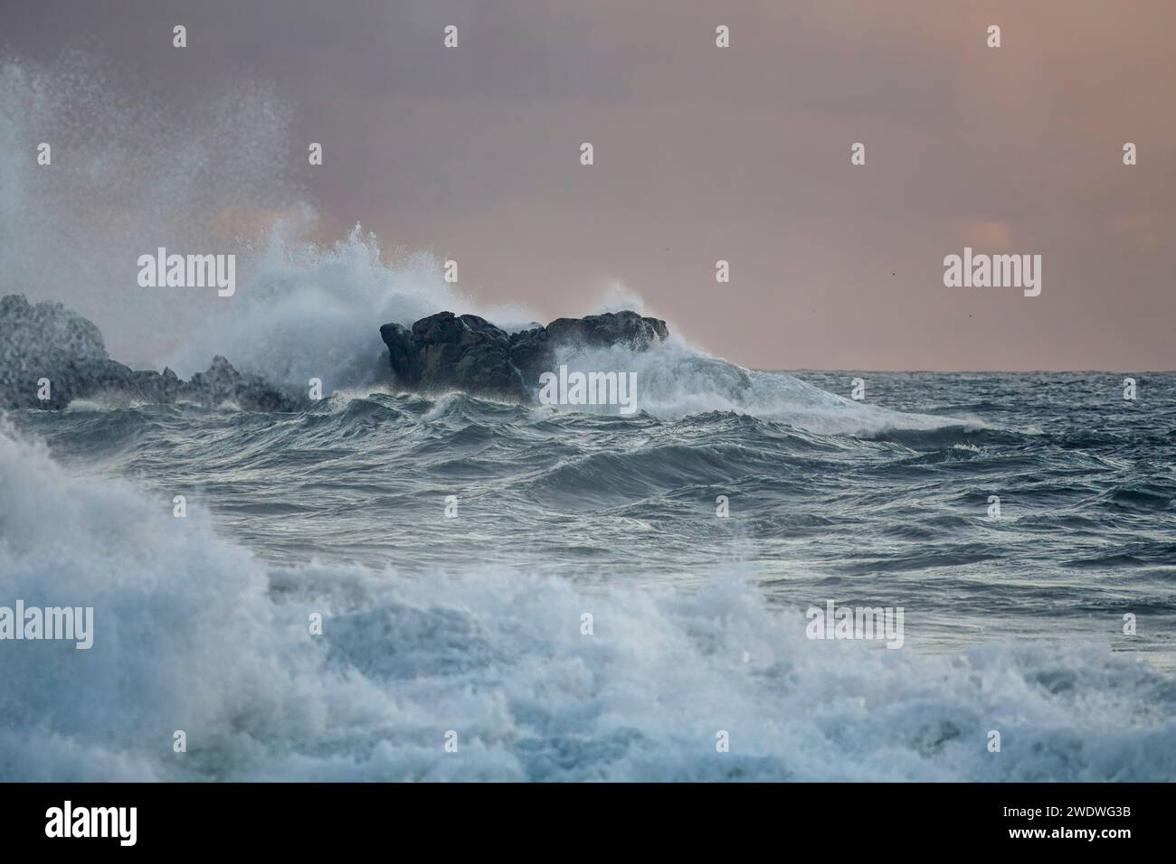 Tempesta di mare al tramonto. Costa rocciosa del portogallo settentrionale. Foto Stock