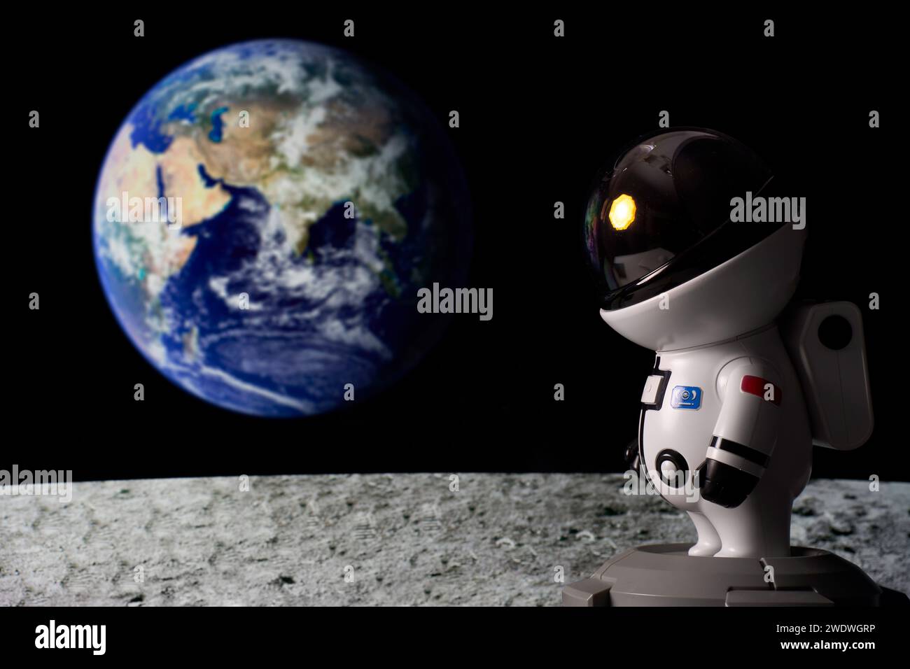 Astronauta nello spazio che guarda il sole dalla superficie lunare e la Terra sullo sfondo. Foto Stock