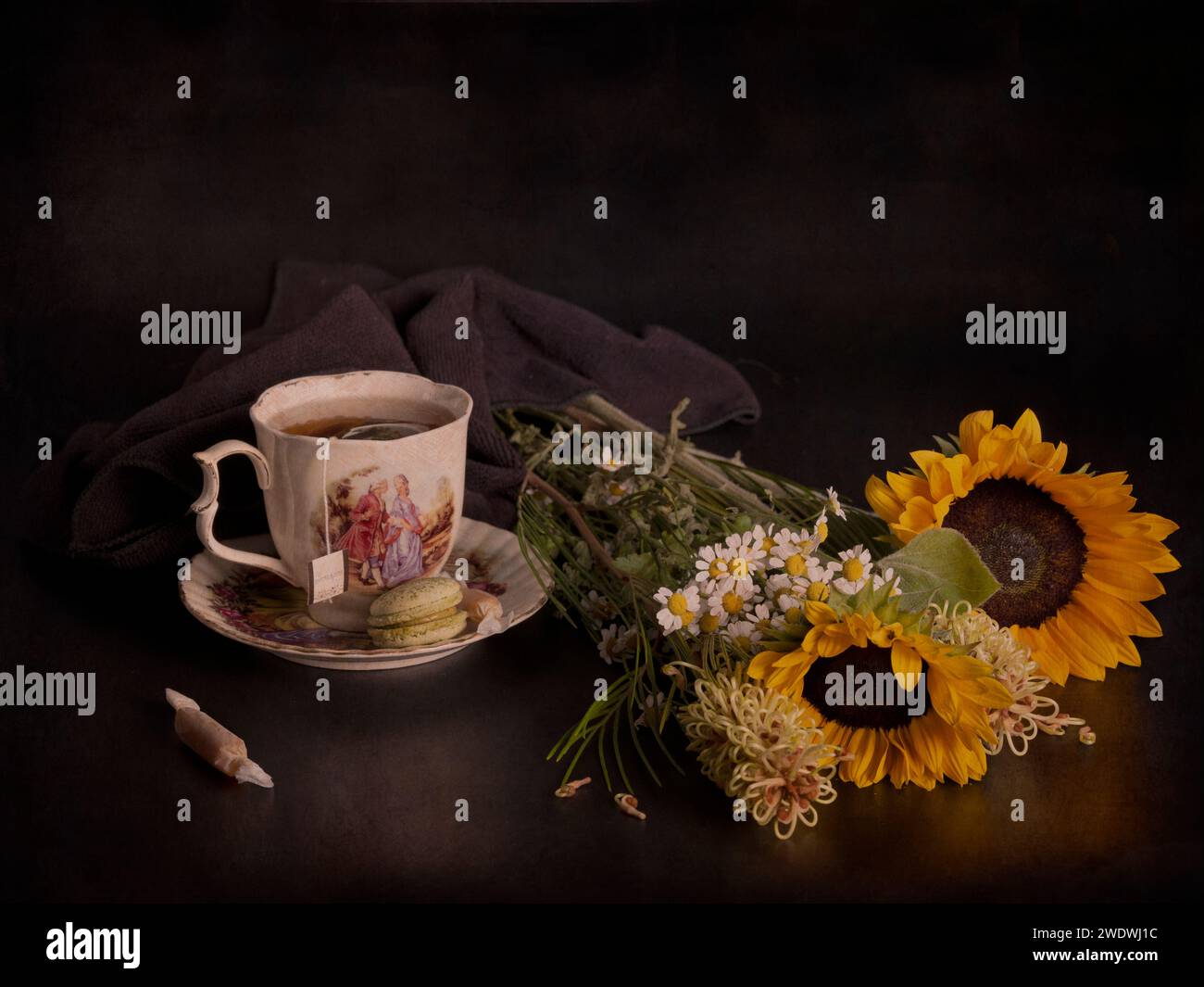 Natura morta atmosferica ed emotiva con una tazza di tè e fiori Foto Stock