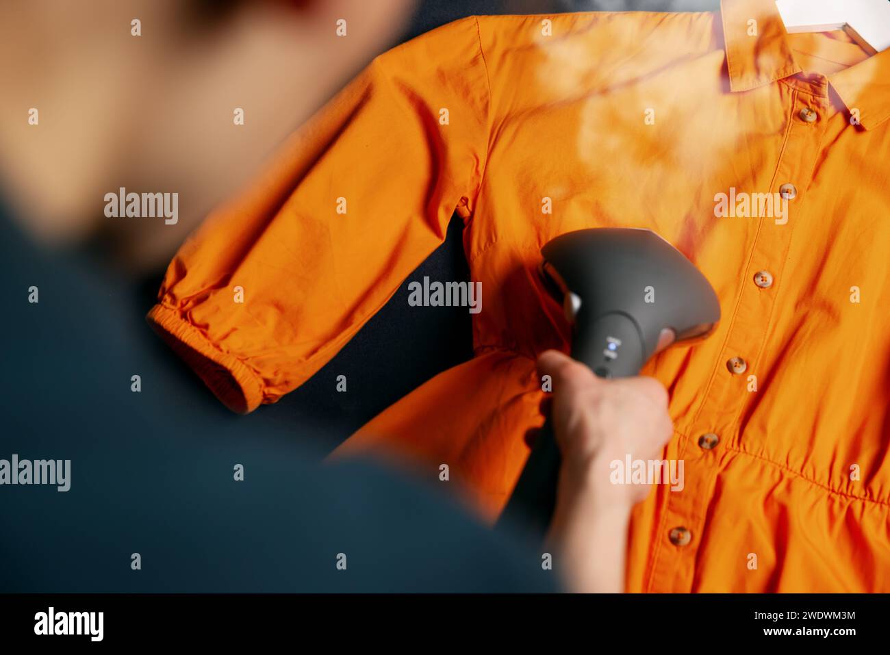 abito da donna con caldaia a vapore sul divano a casa Foto Stock