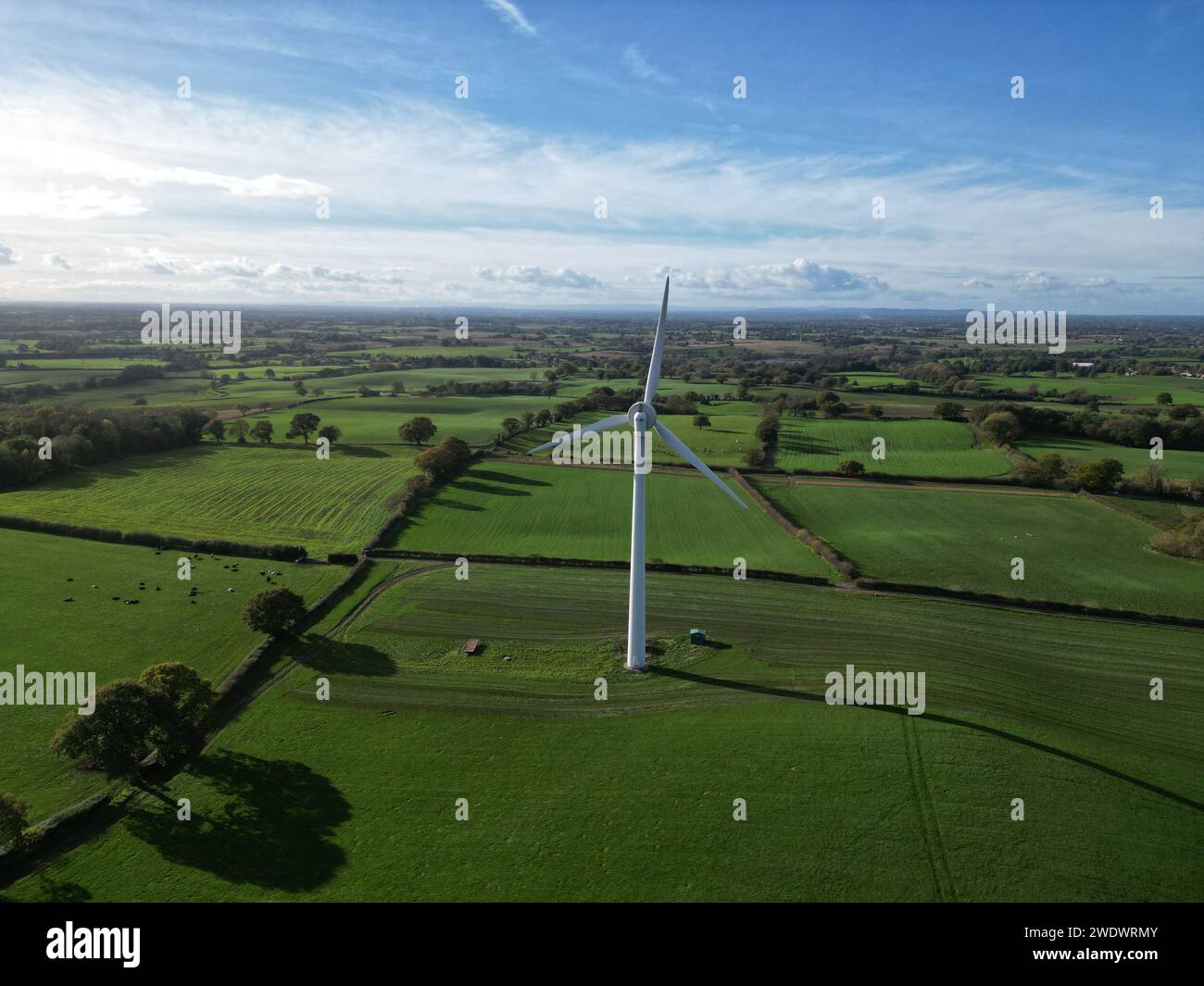 Un drone aereo di una turbina eolica onshore in campo su terreni agricoli, terreni agricoli, giorno, sole, ombra Foto Stock