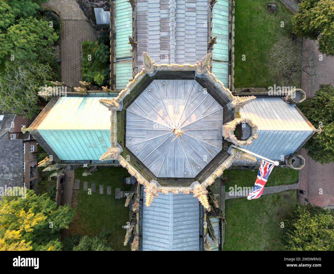 Una vista aerea di un grande edificio con quadranti a orologio e l'iconica bandiera Union Jack in primo piano Foto Stock