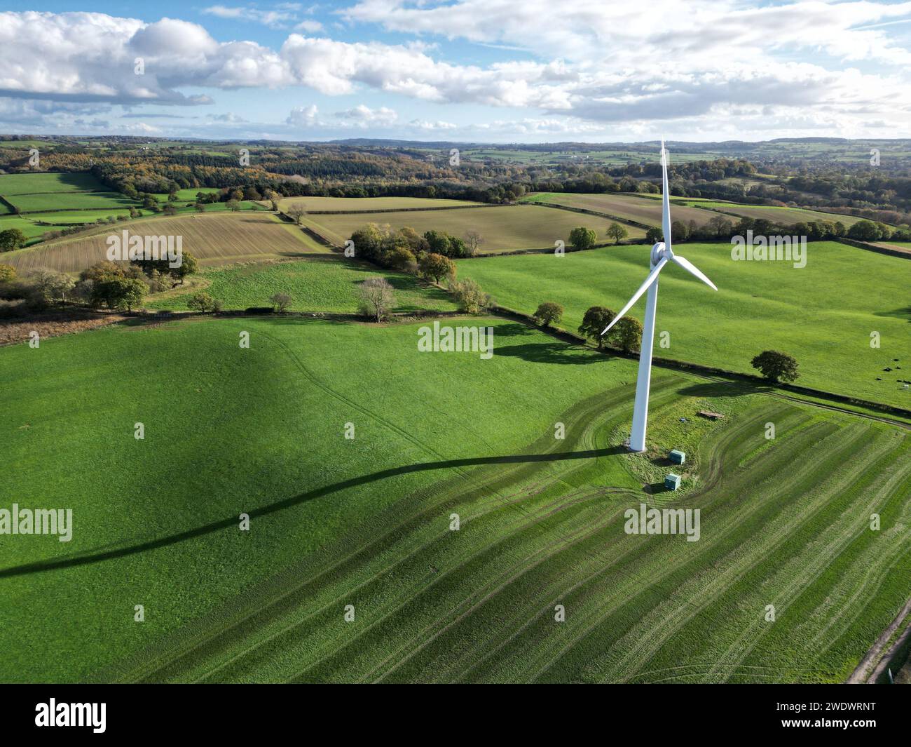 Un drone aereo di una turbina eolica onshore in campo su terreni agricoli, terreni agricoli, giorno, sole, ombra Foto Stock