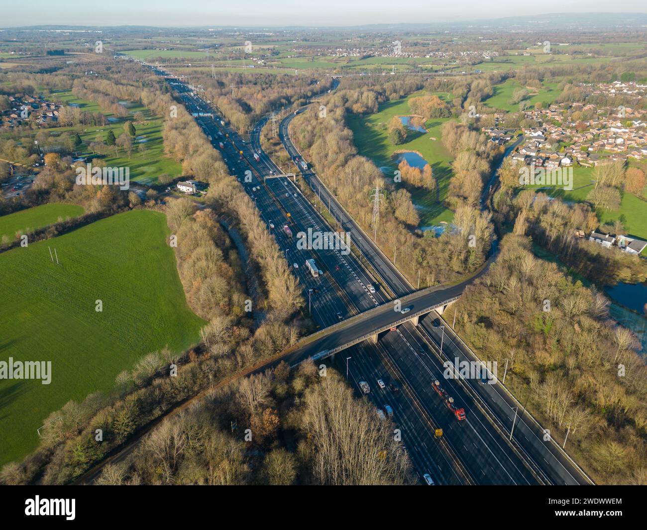 Immagine aerea dell'autostrada M6 a Birchwood, Warrington, Regno Unito, guardando a nord un ponte autostradale e la rampa di raccordo 21A con case e campi Foto Stock