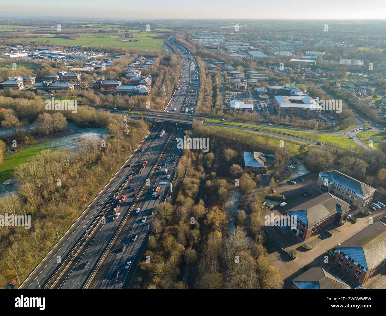 Fotografia aerea che guarda a sud lungo l'autostrada M6 a Birchwood, Warrington, Regno Unito, con il ponte Birchwood Way e i centri commerciali e commerciali Foto Stock