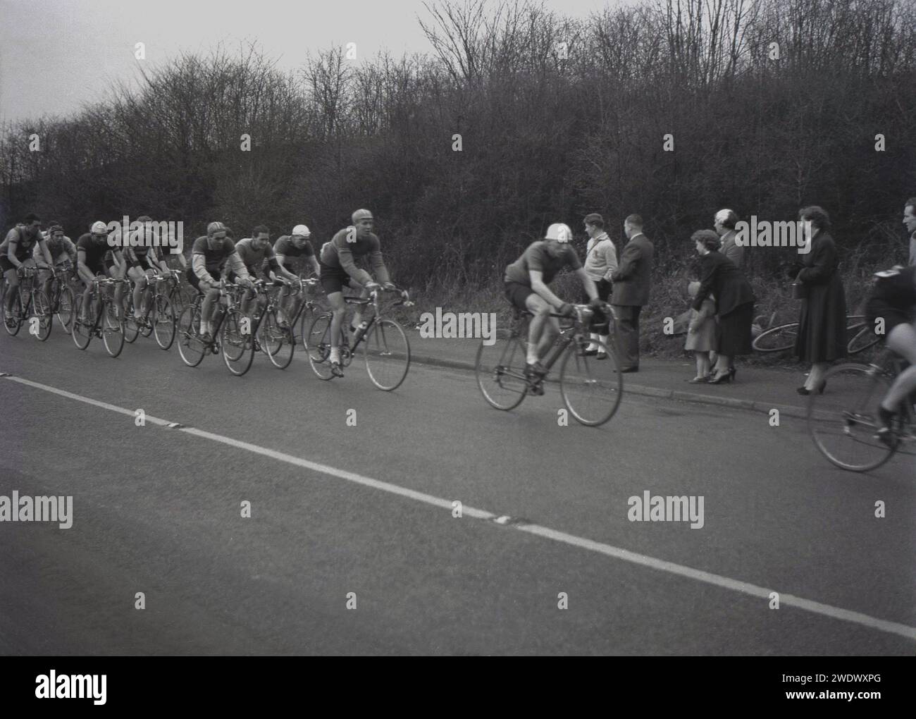1952, storico, sport ciclistico, gara su strada, concorrenti in gara nel Daily Express Tour of Britain, Inghilterra, Regno Unito, guardati dagli spettatori sul posto. Foto Stock