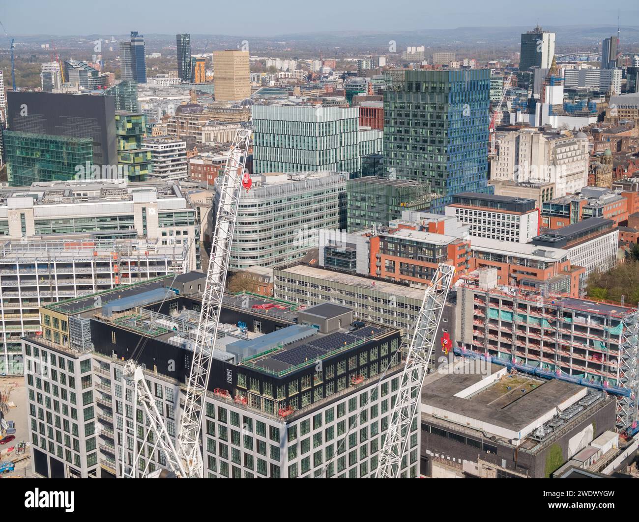 Fotografia aerea di gru a torre e costruzioni al Manchester Goods Yard con Spinningfields, centro di Manchester, Regno Unito sullo sfondo Foto Stock