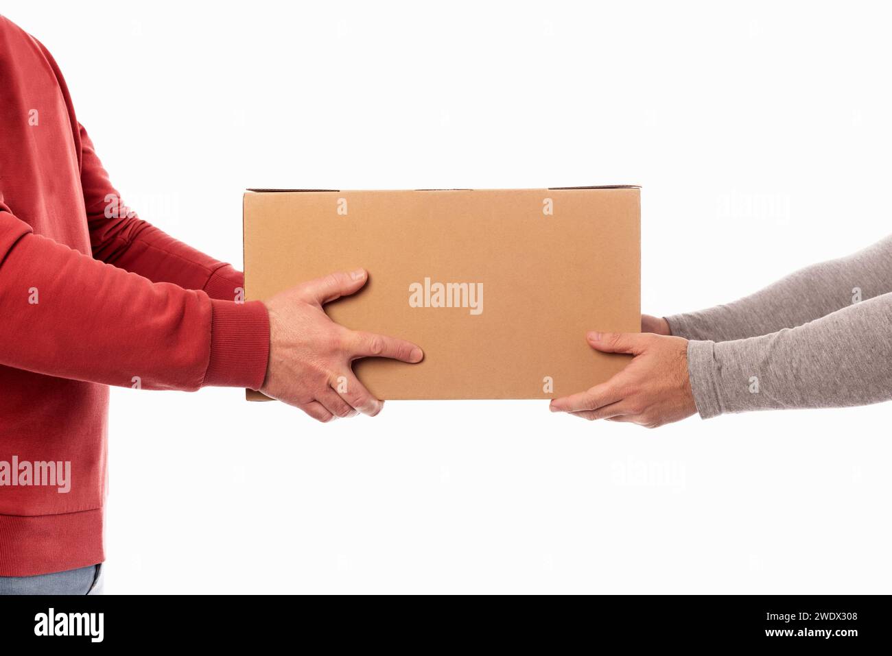 Addetto alla consegna con maglione rosso che consegna una scatola a un cliente. Servizio di consegna a domicilio. Consegna tramite corriere. Ricezione di un pacchetto da un acquisto online Foto Stock