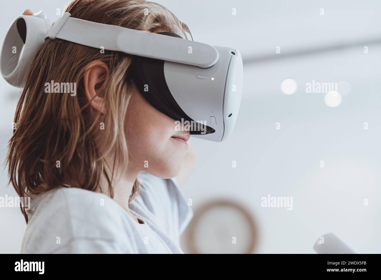 Un bambino simpatico gioca a un gioco di realtà virtuale Foto Stock