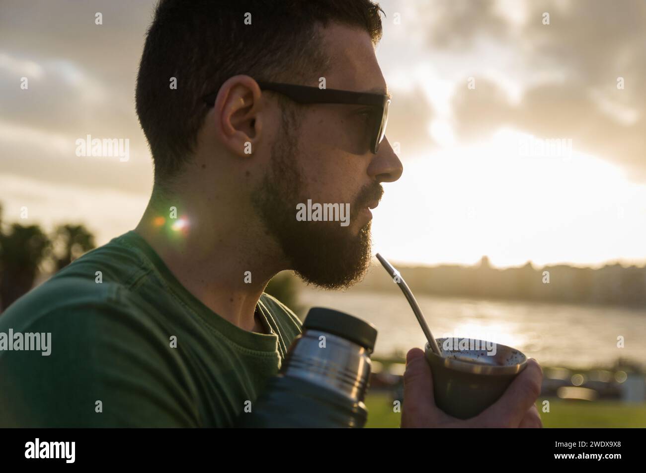 Uomo che beve chimarrao, mate (un'infusione di yerba mate con acqua calda) al tramonto in uruguay Foto Stock