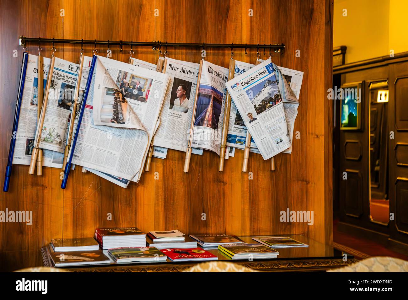 Una selezione di giornali è appesa sui loro bastoni di giornale nella biblioteca del tradizionale Hotel Waldhaus Sils nella Biblioteca dell'Hotel Waldhaus Sils im Engadin/Segl, Svizzera Foto Stock