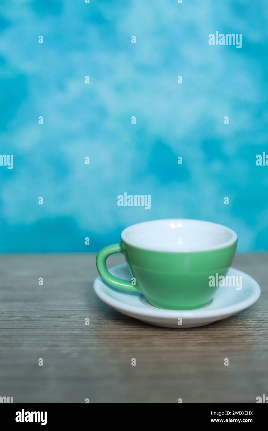 tazza di caffè verde su sfondo blu. Minimalismo. Foto Stock