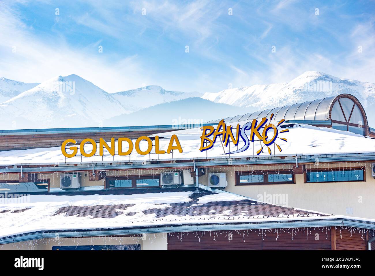 Bansko, Bulgaria - 20 dicembre 2023: Stazione sciistica invernale bulgara, cartello con il nome della stazione di risalita della funivia e montagne innevate, inverno Foto Stock
