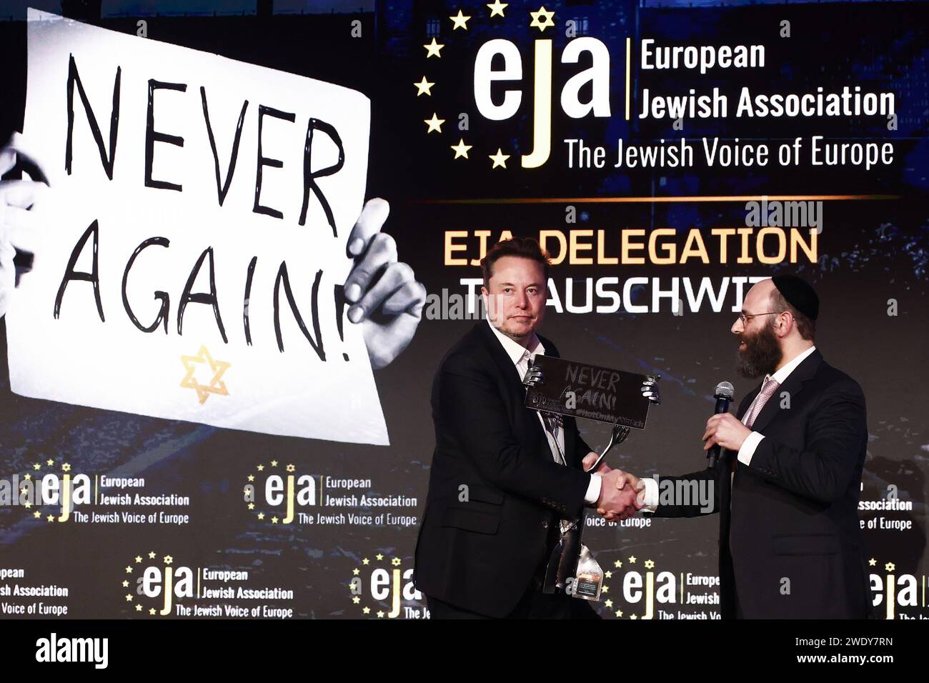 Cracovia, Polonia. 22 gennaio 2024. ELON MUSK, proprietario di Tesla e della piattaforma X (ex Twitter), riceve la statuetta "Never Again" dal presidente dell'EJA Rabbi Menachem Margolin, durante un simposio sulla lotta all'antisemitismo intitolato "Never Again : Lip Service or Deep Conversation" a Cracovia. Musk, che è stato invitato in Polonia dall'Associazione ebraica europea (EJA) ha visitato il campo di concentramento di Auschwitz-Birkenau all'inizio di quel giorno, in vista della giornata internazionale della memoria dell'Olocausto. Crediti: ZUMA Press, Inc./Alamy Live News Foto Stock