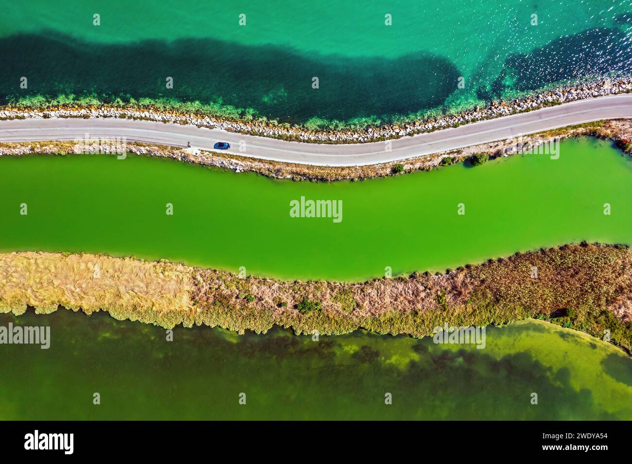 La strada per l'isola di Koronissia con il golfo di Ambracian ("Amvrakikos") da un lato e la laguna di Logaros dall'altro. Arta, Epiro, Grecia. Foto Stock