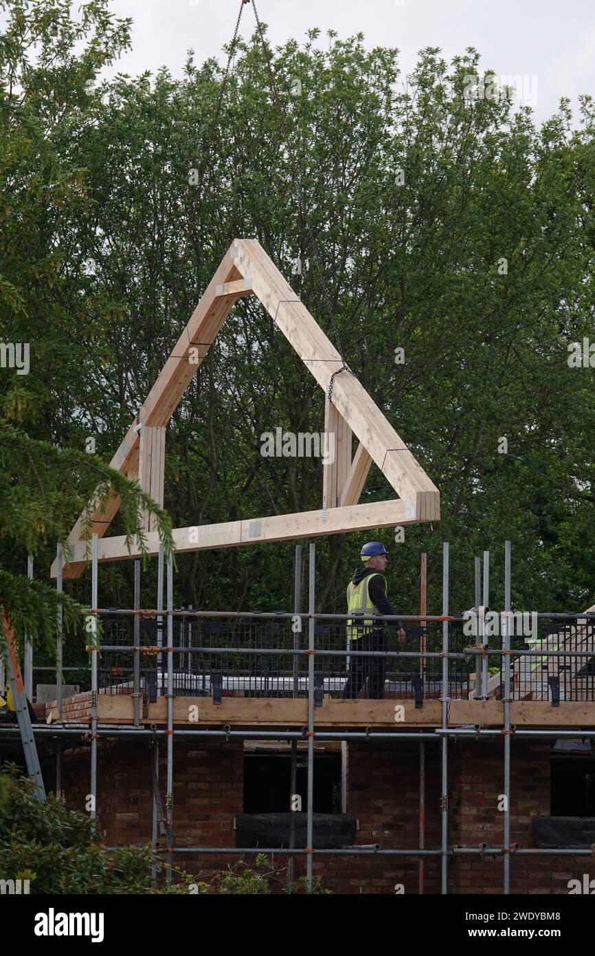 Capriate per tetti installate mediante gru in un cantiere di un edificio residenziale Foto Stock