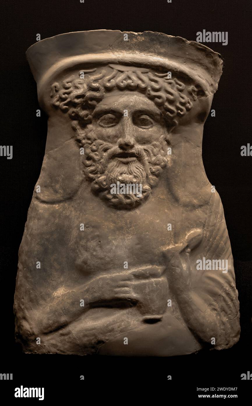 Benaki MuseumQuesto busto in terracotta del Dio greco Dioniso risale al 380-360 a.C. Indossa uno stephane (un tipo di fascia metallica capovolta) nei capelli e tiene un uovo nella mano sinistra e una brocca per il vino sulla destra. Atene Grecia. Foto Stock