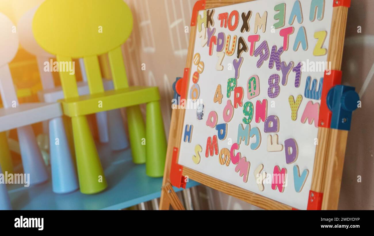 Apprendimento magnetico numeri multicolori su una lavagna bianca della scuola elementare. Attività educativa per lo sviluppo precoce dei bambini. Foto Stock