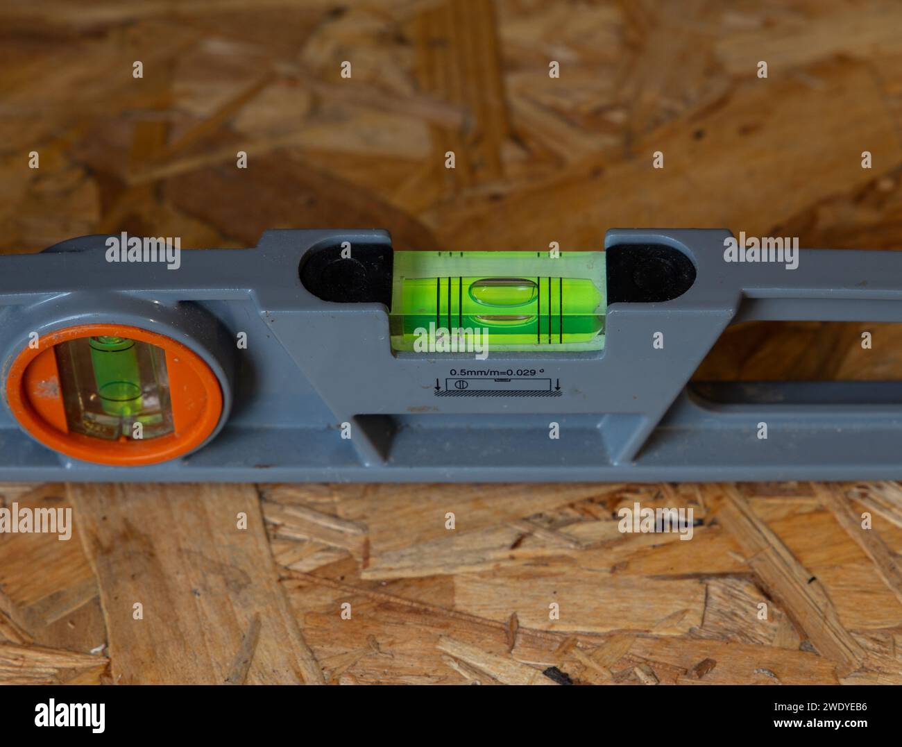 Primo piano di una livella a bolla d'aria su una panca di legno che mostra la bolla d'alcol centrale Foto Stock