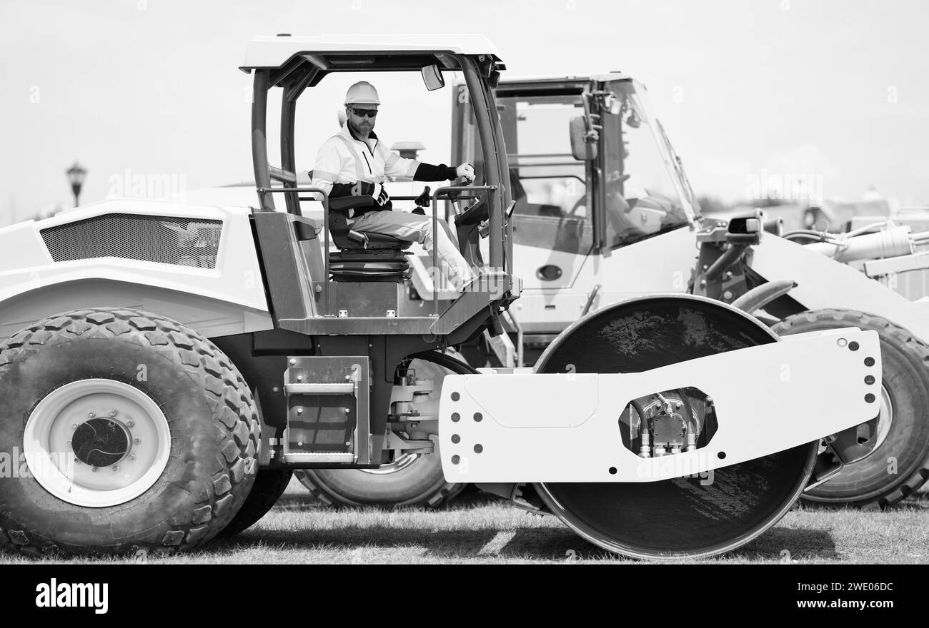 uomo lavoratore a costruzione macchine all'aperto. l'uomo che lavorava nell'edilizia utilizzava un rullo vibrante. lavoratore occupato su attrezzature da costruzione. costruzione Foto Stock