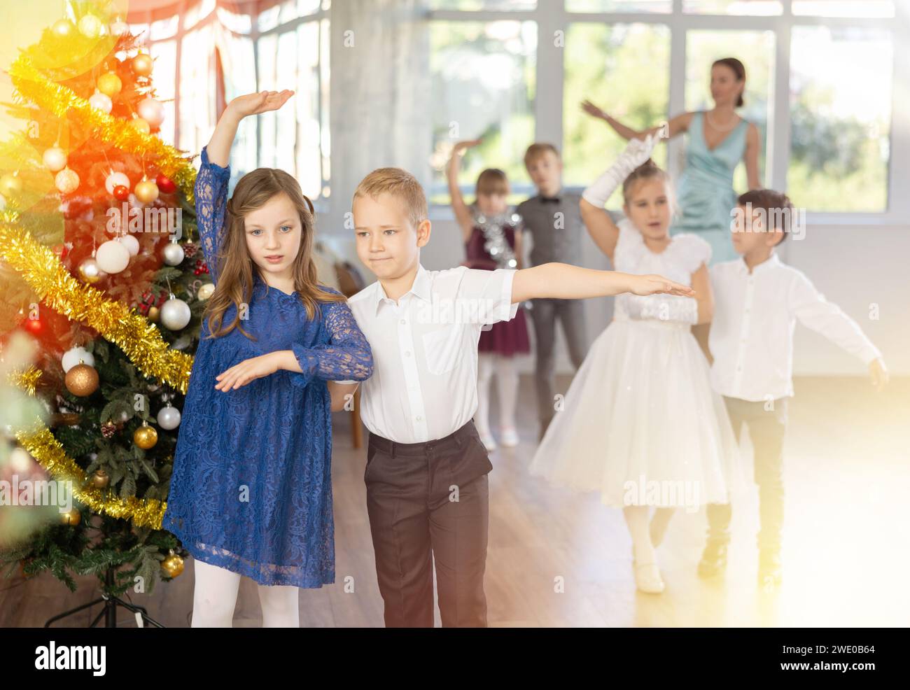 Ballo di Natale - i bambini vestiti splendidamente ballano il valzer viennese vicino all'albero di Capodanno Foto Stock