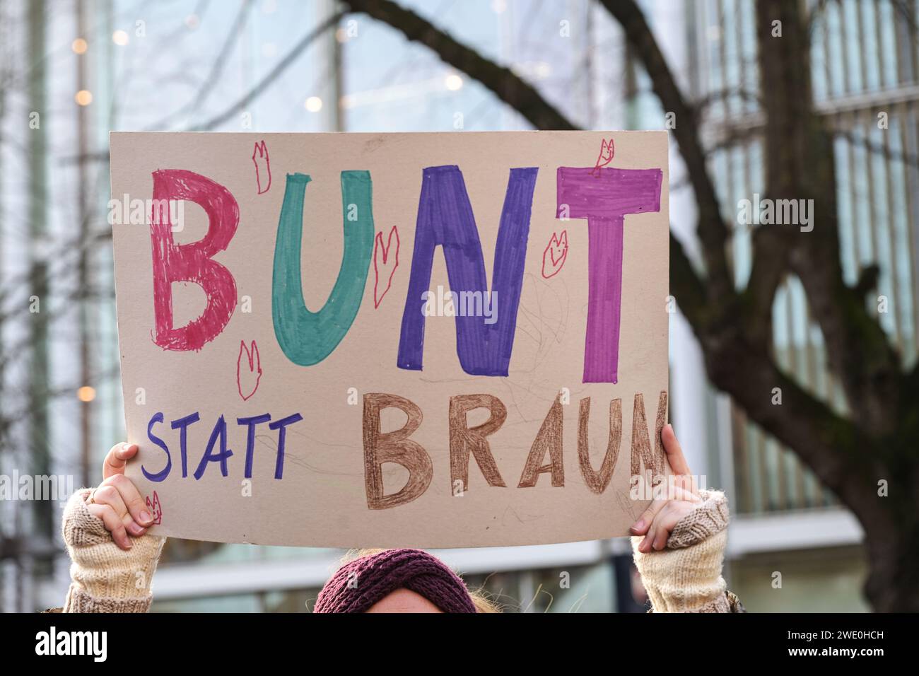 Donna con un cartello di cartone con il testo tedesco Bunt statt Braun (colorato invece di Brown), come protesta contro il razzismo e il fascismo neonazista su A. Foto Stock